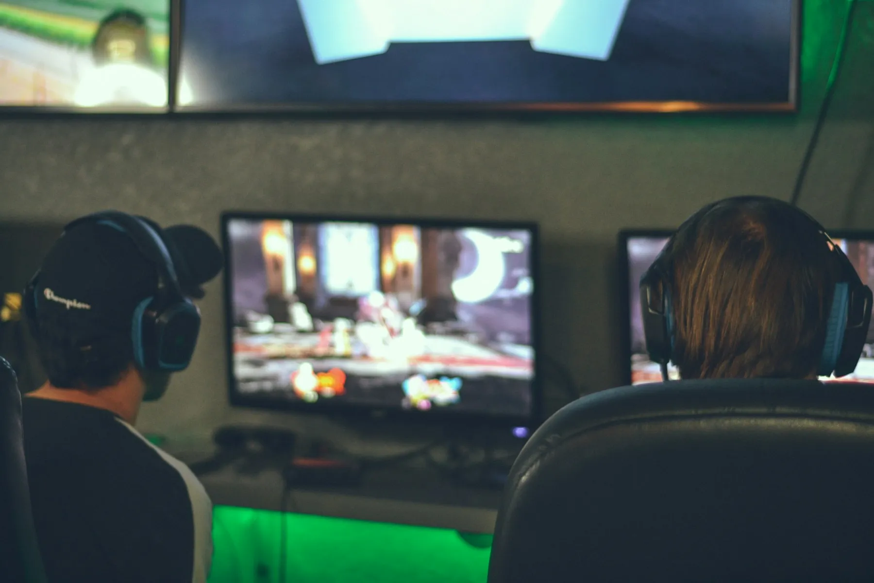Two competitors focused on matches at adjacent monitors