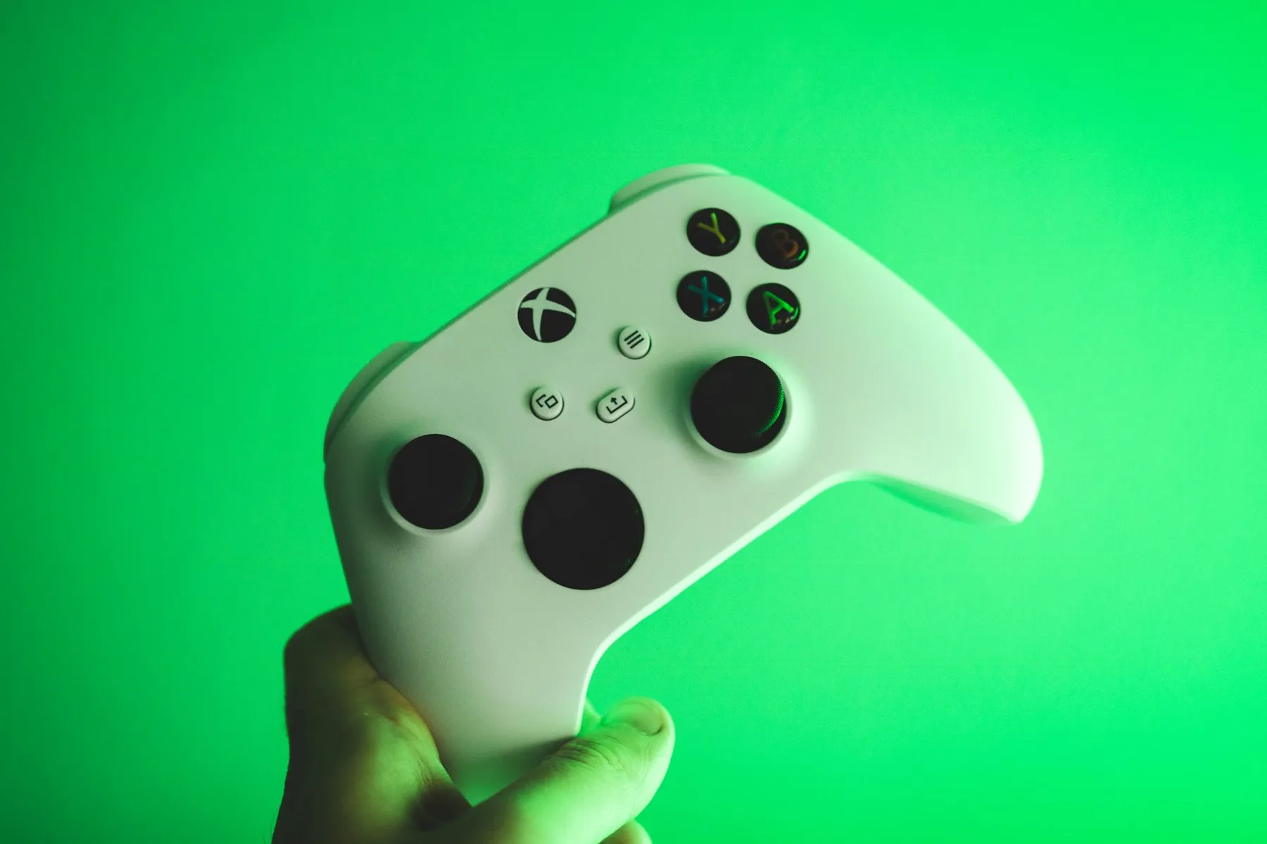 A white and black Xbox controller on a green surface