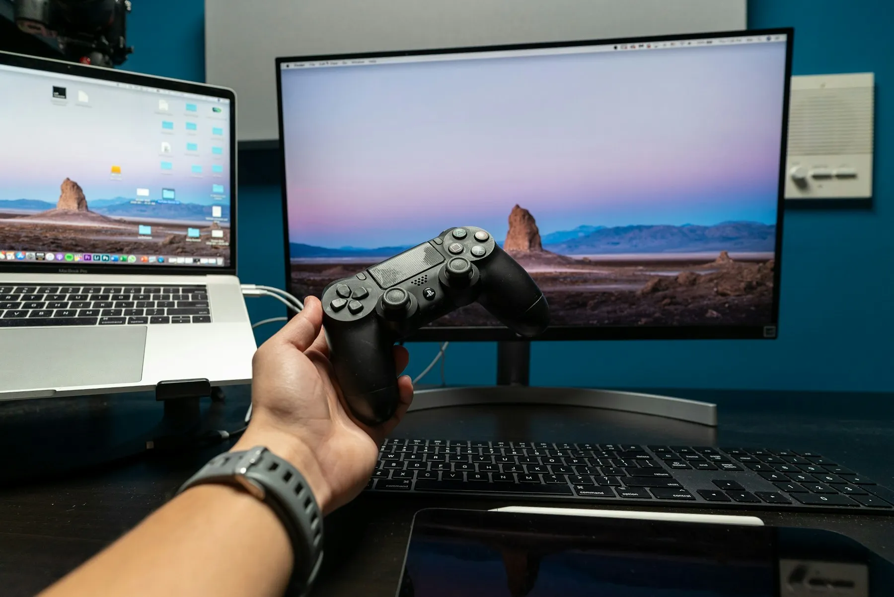 A player holding a black controller in a gaming setup