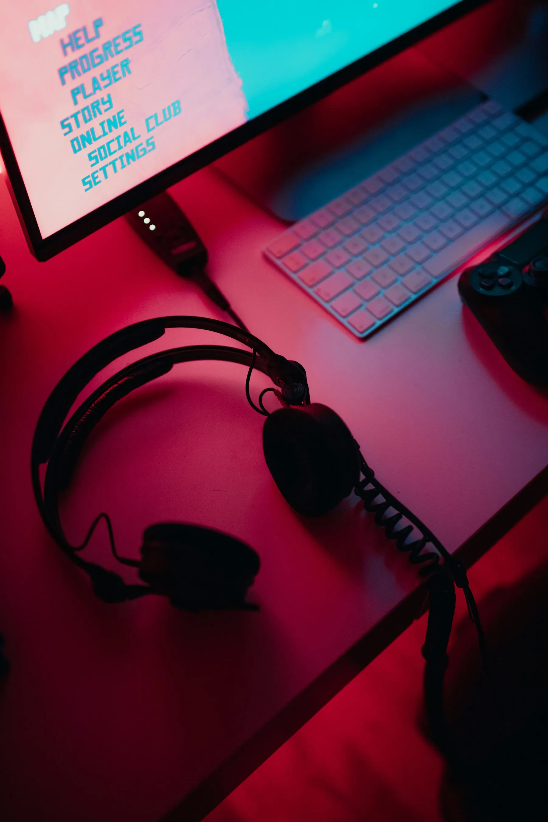 A headset beside a lit computer monitor