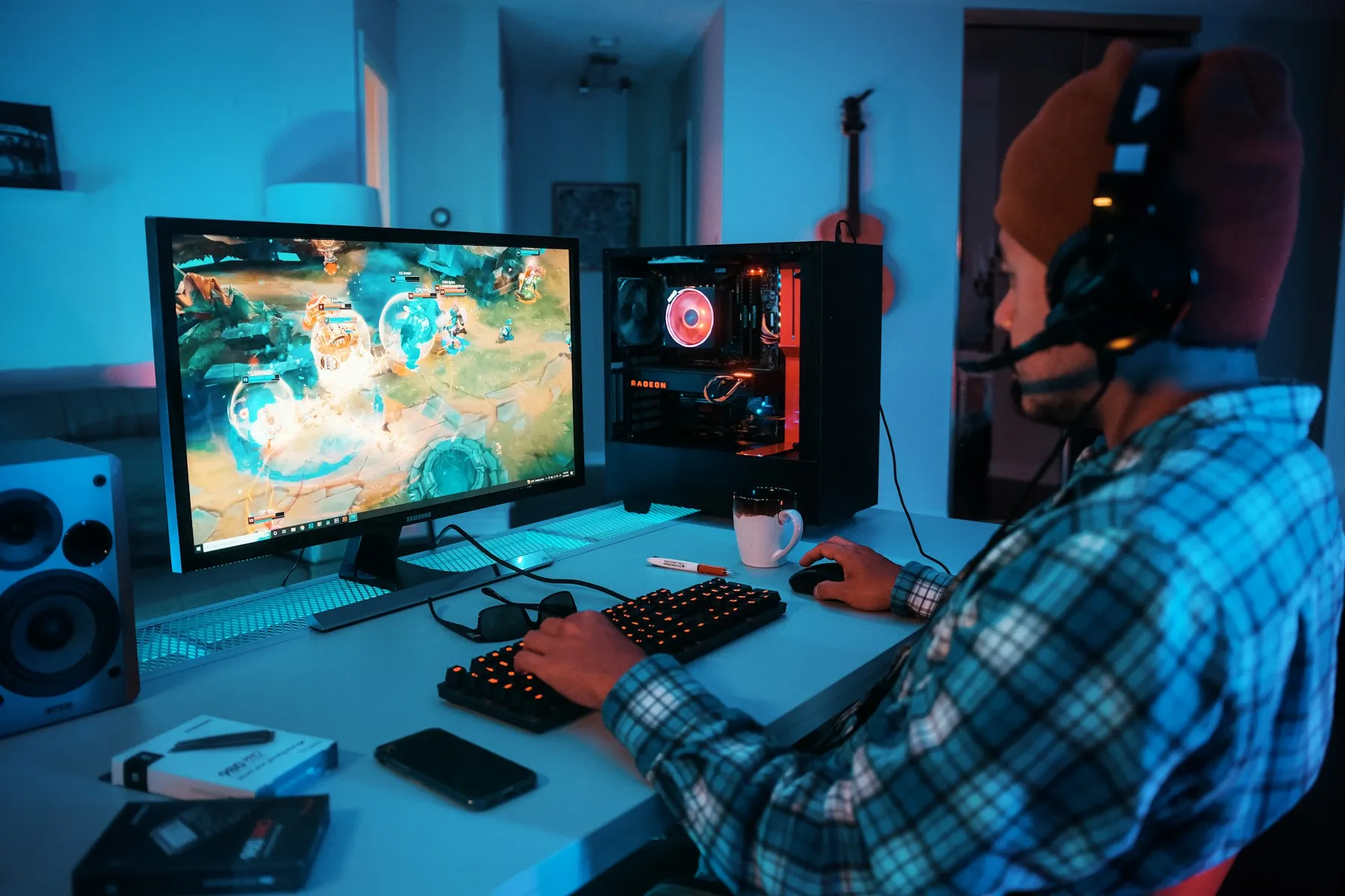 A player wearing headphones at a gaming computer